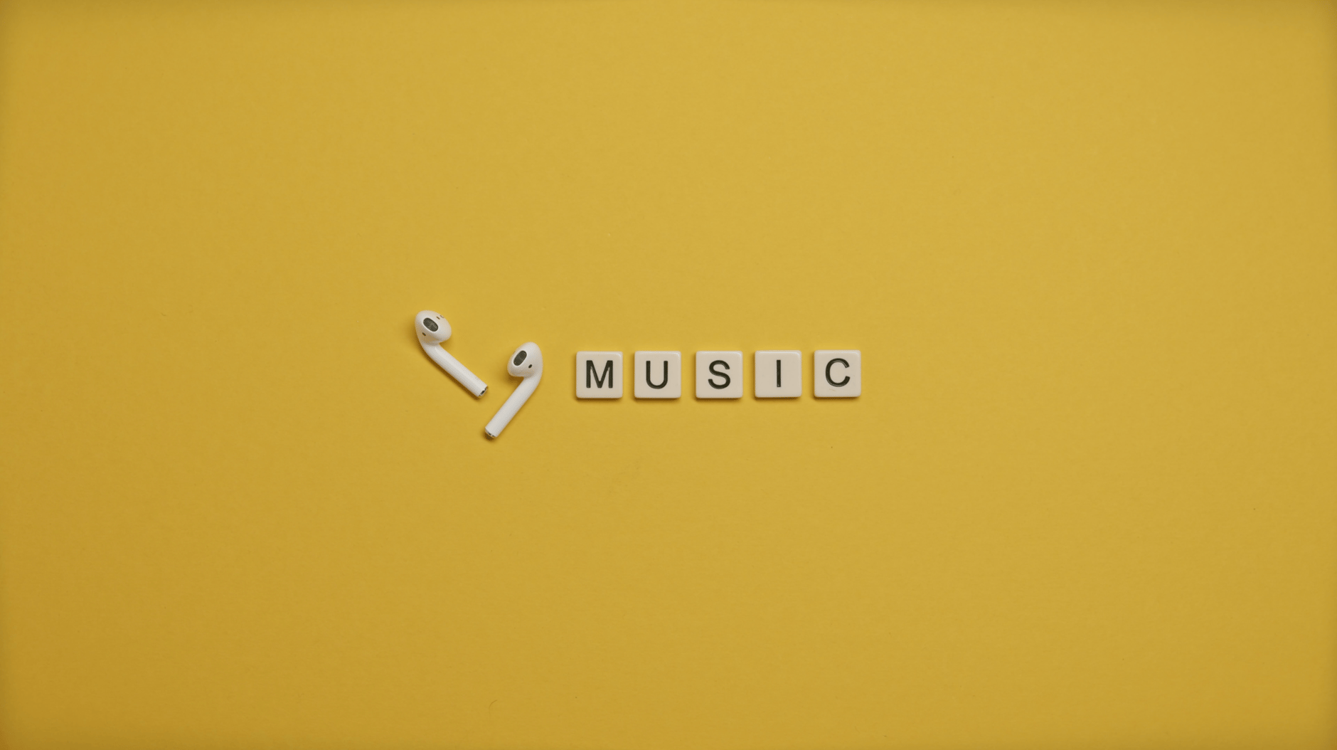 a pair of air pods beside a black and white music text